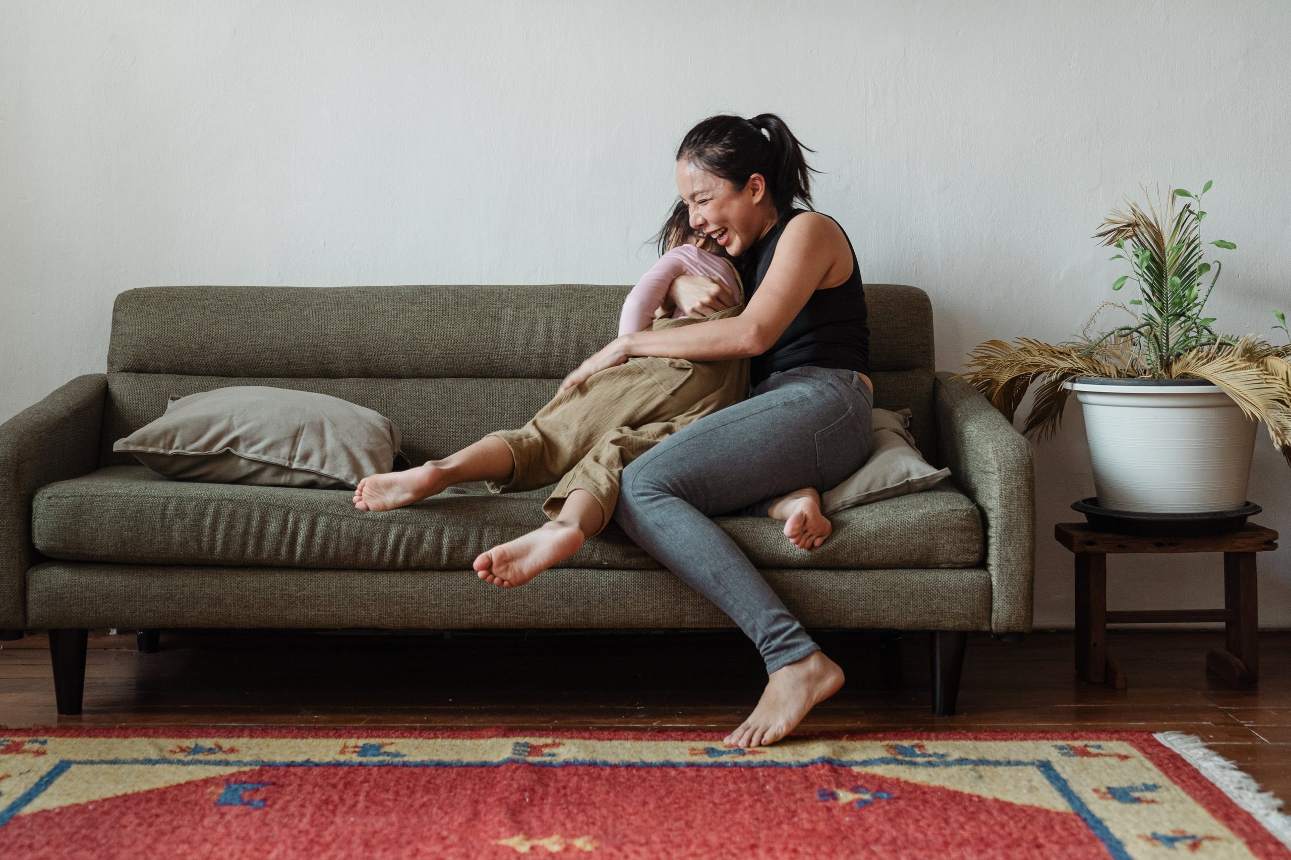 mãe e filha brincando no sofá